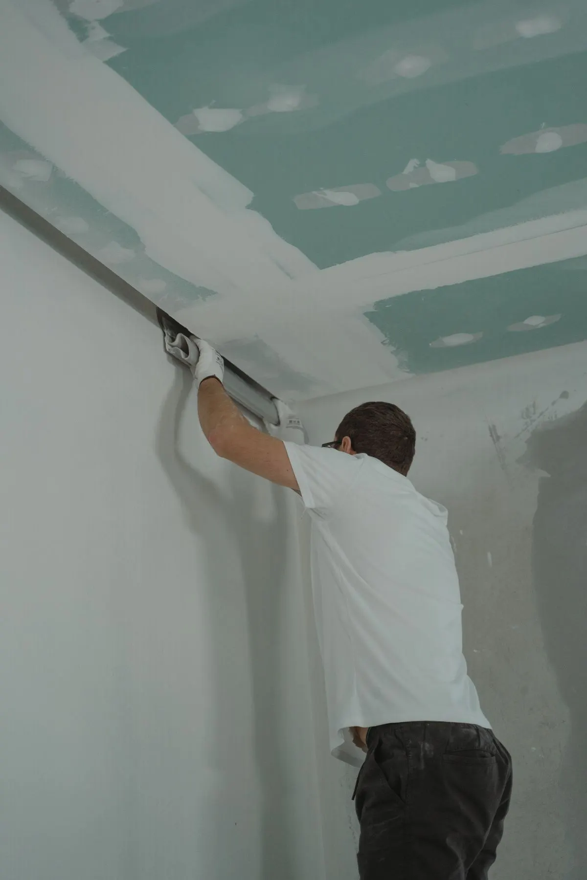 Drywall professional taping and finishing a wall
