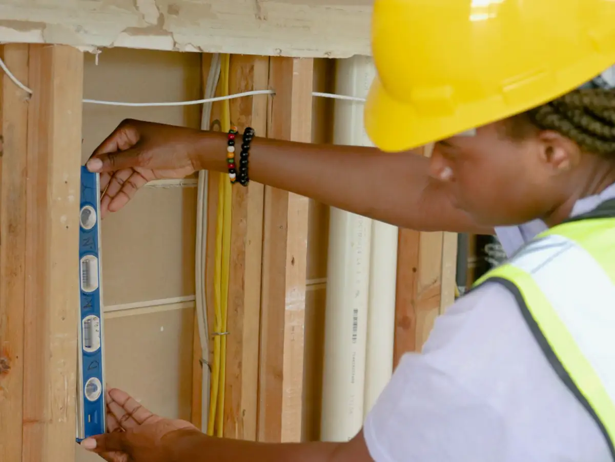 Construction worker using a spirit level to check commercial wood framing