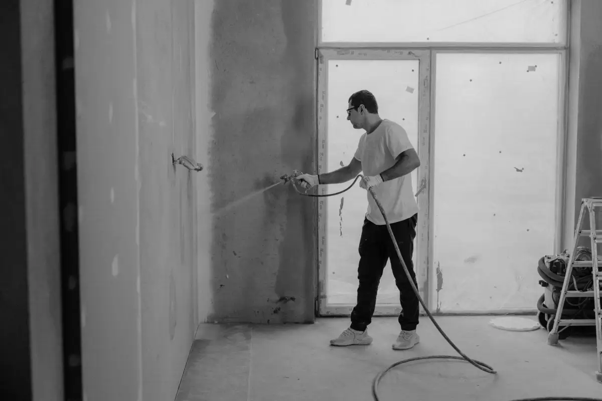 Worker spraying wall texture during a renovation