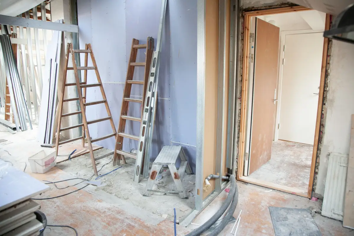Room set up with ladders and tools for a popcorn ceiling removal project
